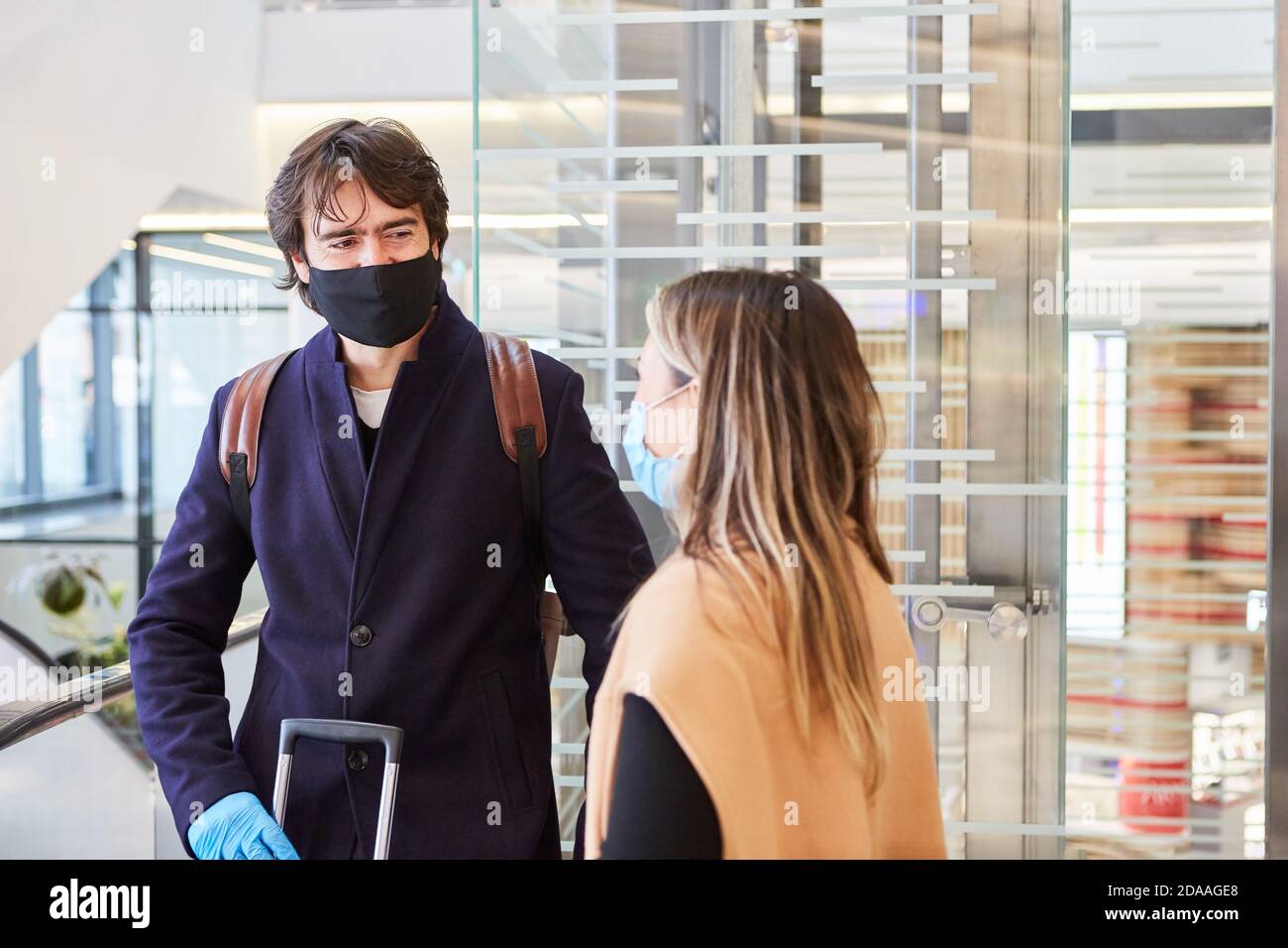 Viaggiatori d'affari con maschere per la pandemia del Covid-19 in aeroporto Foto Stock