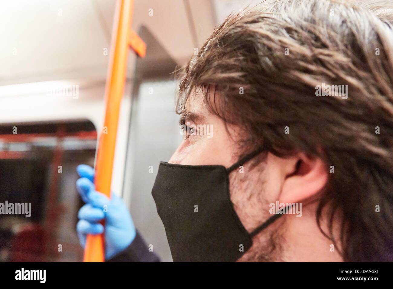 Uomo come passeggero con maschera facciale a causa di Covid-19 pandemia su autobus e treni Foto Stock