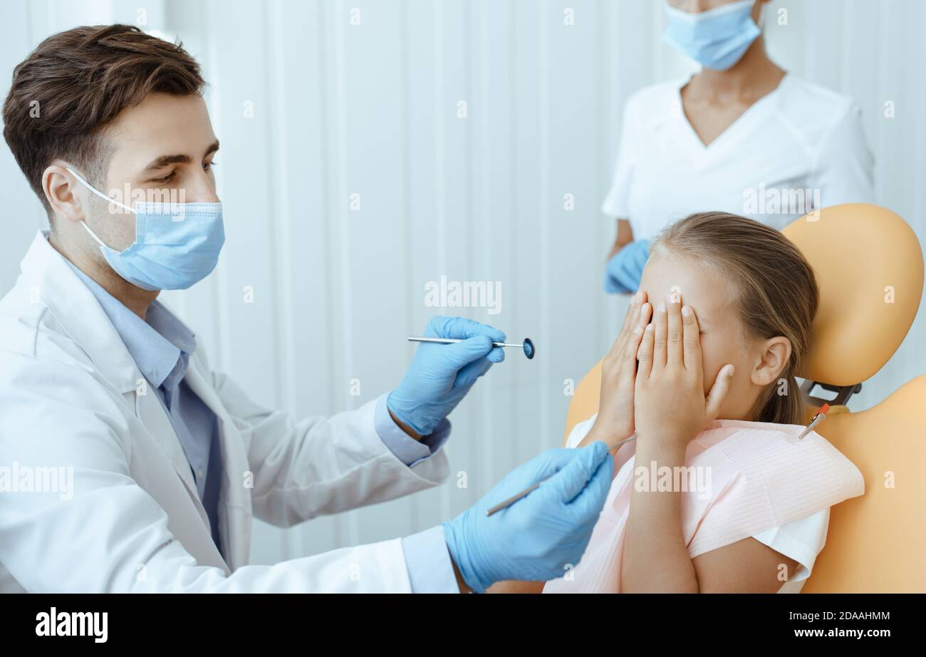 Dentista che esamina i denti dei pazienti nel moderno ufficio odontoiatrico Foto Stock