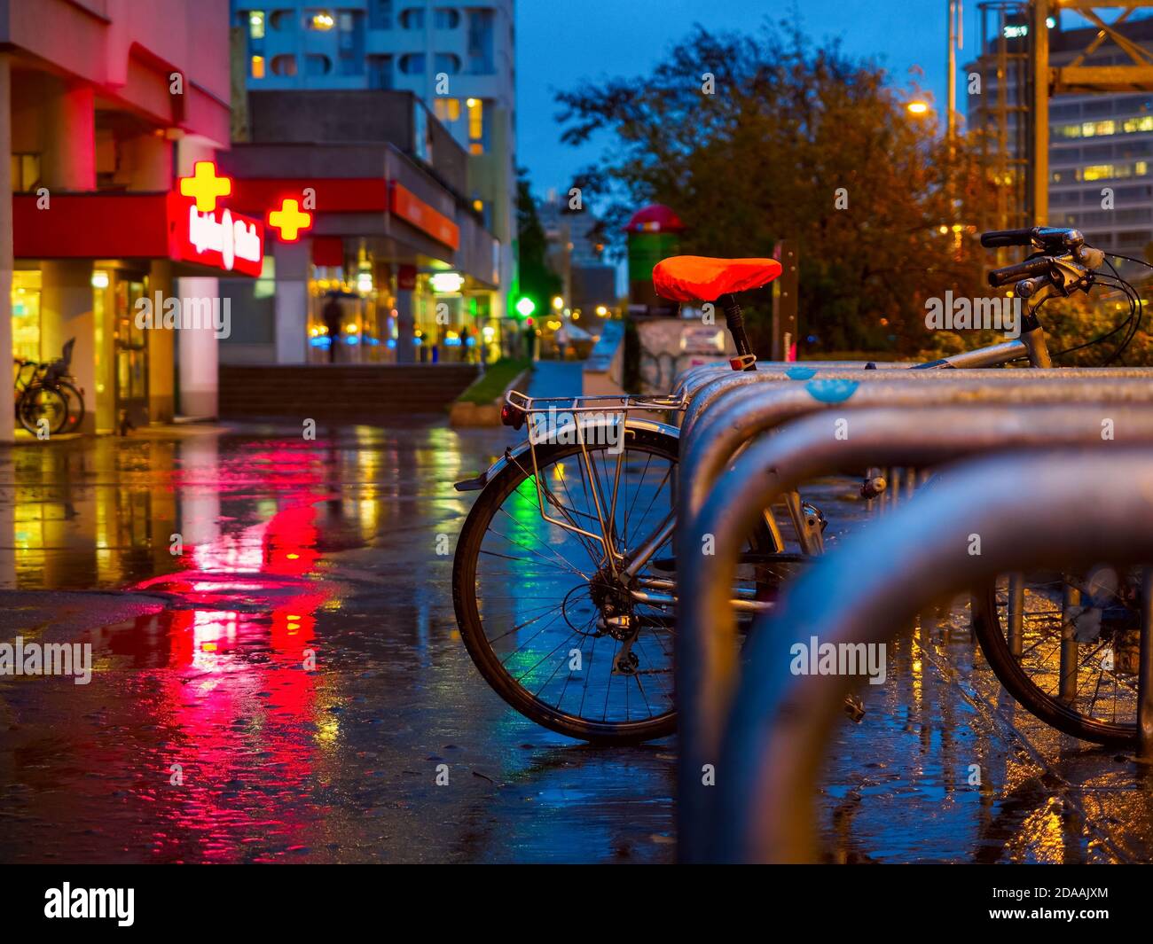City Bicycle Parcheggio su una strada in una notte piovosa. Foto Stock