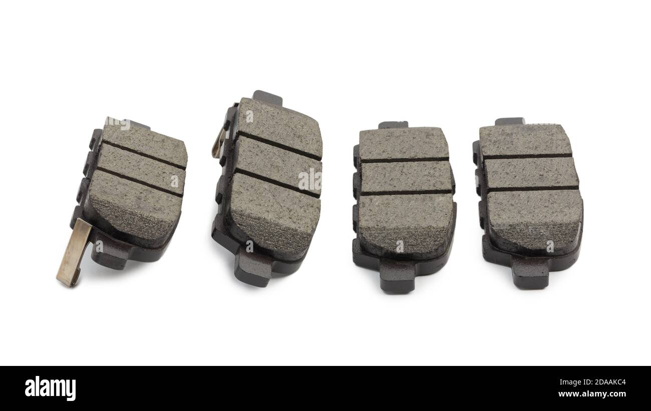 Set di nuove pastiglie dei freni per auto isolate su sfondo bianco con ombra. Messa a fuoco superficiale. Foto Stock