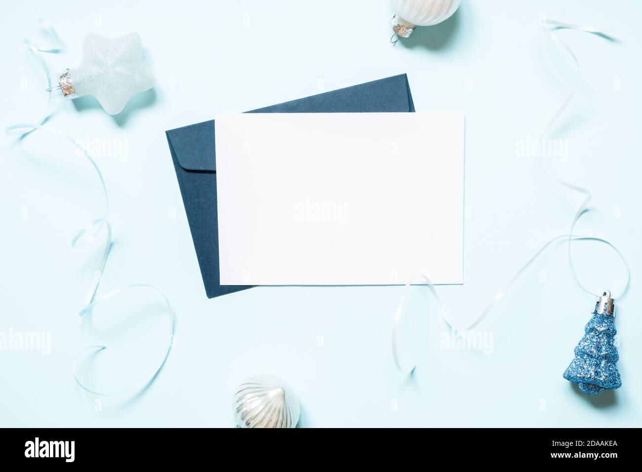 Carta di natale vuota e decorazioni su sfondo blu. Foto Stock