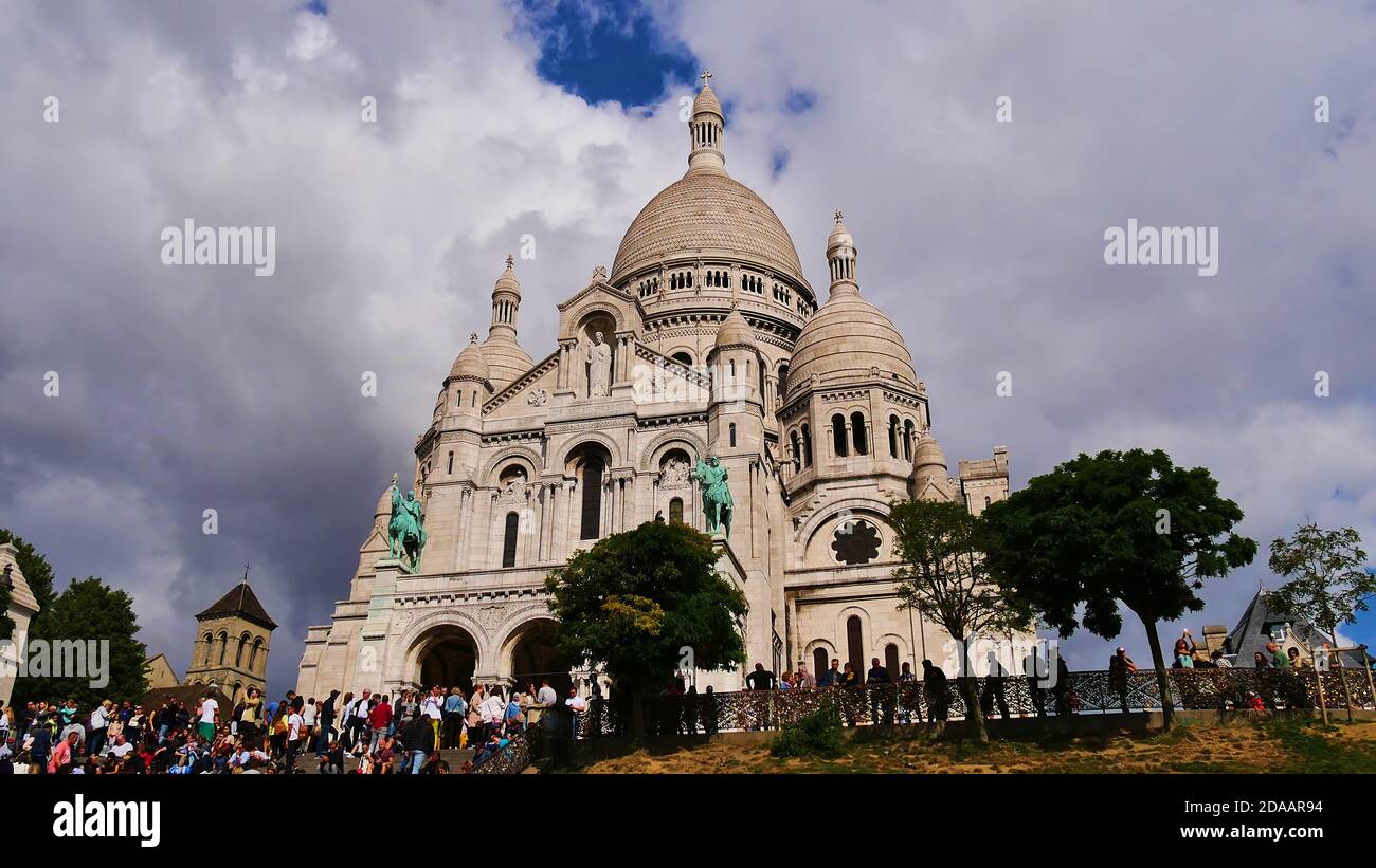 Folla di turisti che godono la vista di fronte alla maestosa Basilica del Sacro cuore (Basilica del Sacro cuore) di Parigi, Francia situata su Montmartre. Foto Stock