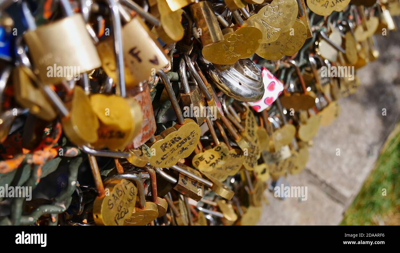 Vista closeup di un gran numero di lucchetti d'amore color oro (lucchetti) bloccati ad una recinzione da dolcetto sulla collina di Montmartre a Parigi, Francia. Foto Stock