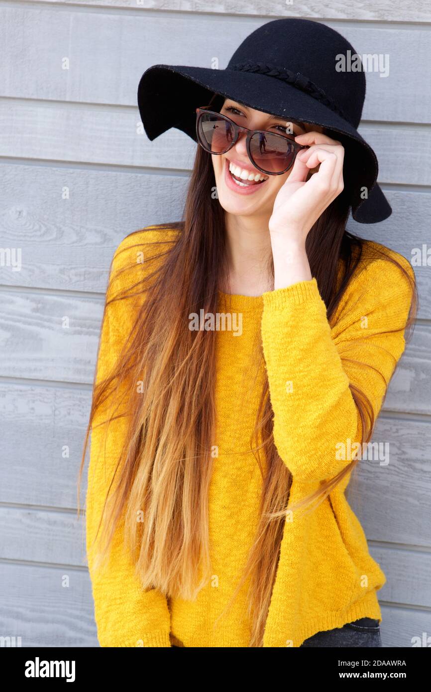 Ritratto di giovane donna alla moda che indossa occhiali da sole e cappello Foto Stock