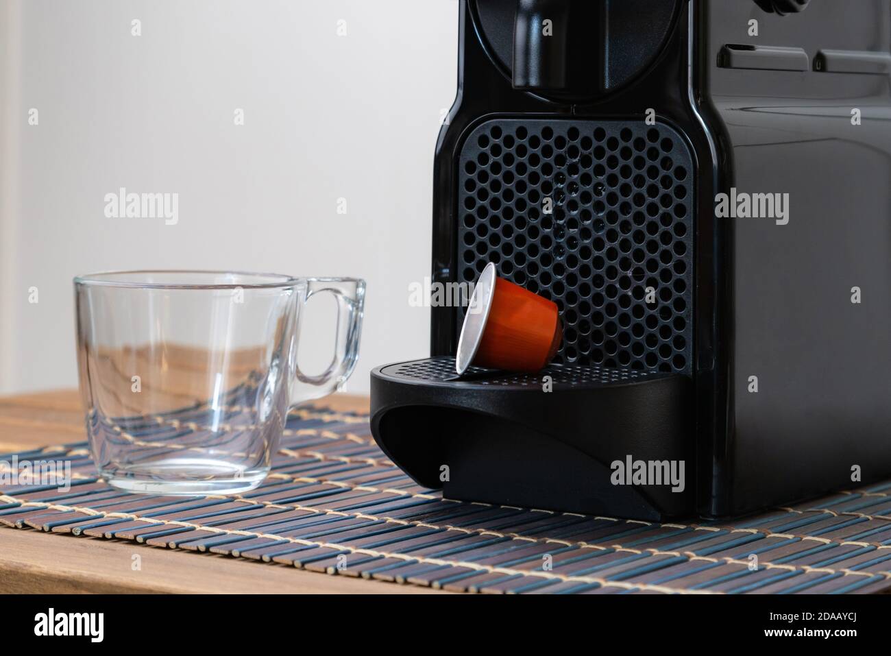 Una vera e propria vita di una capsula e di una tazza di caffè rinfrescanti accanto alla macchina per il caffè all'interno della casa. Nessuno Foto Stock