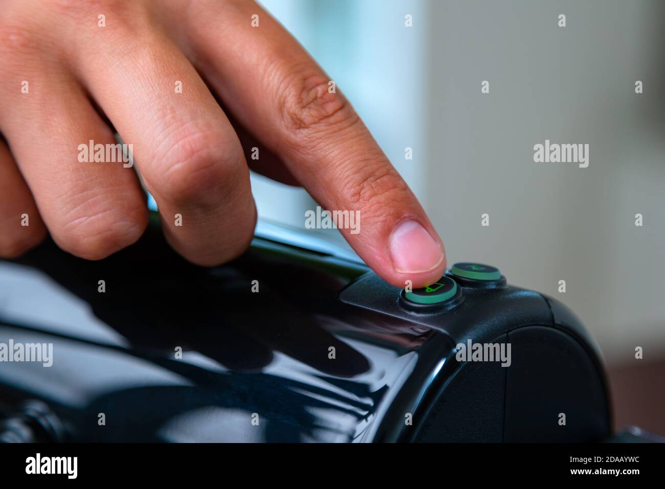 Primo piano della pressione manuale del pulsante su una capsula in una macchina da caffè a casa. Concetto di pausa caffè. Foto Stock