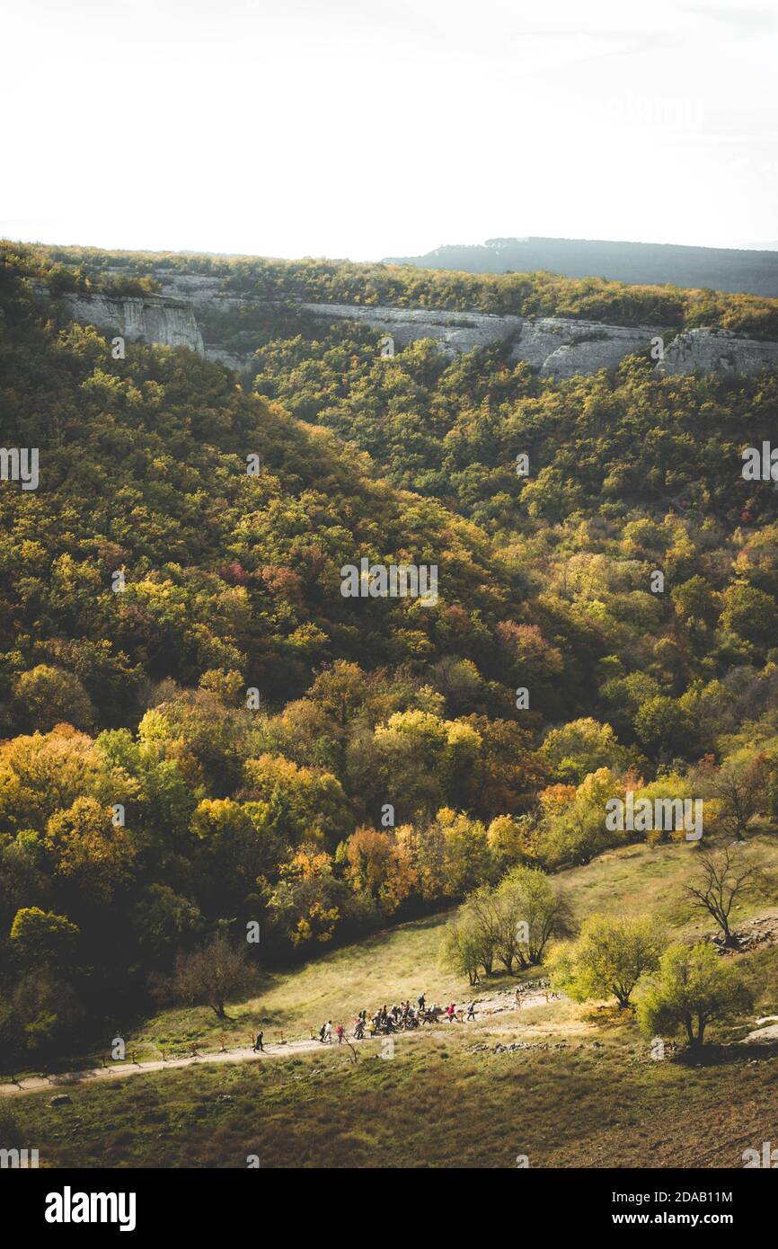 Gruppo di escursionisti che viaggiano sulle colline di montagna con uno sfondo pittoresco. Orizzontale verticale dall'alto Foto Stock