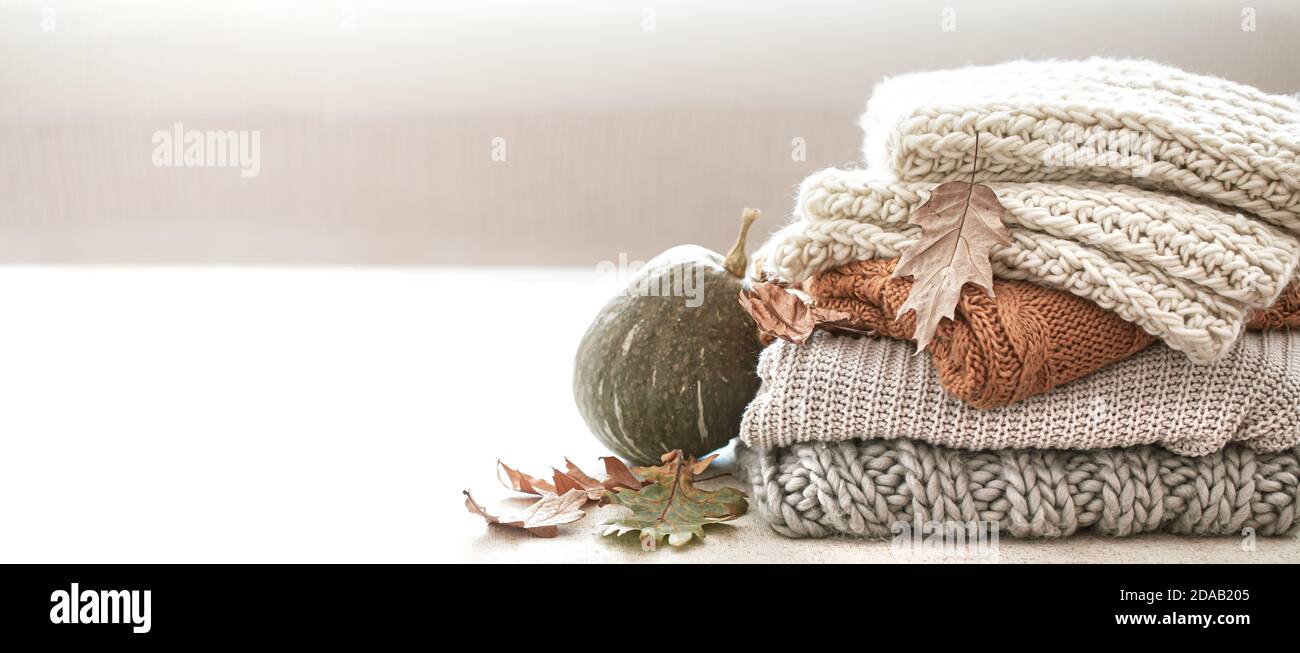 Pila di articoli in maglia calda dal guardaroba autunnale primo piano su sfondo bianco sfocato copia spazio. Foto Stock