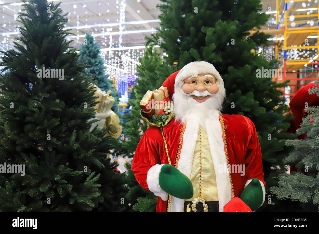 Divertente Babbo Natale sorridente in un cappello rosso, bello Capodanno e Natale giocattolo, decorazioni. Natale Natale inverno shopping, vendita. Negozio di giocattoli Foto Stock