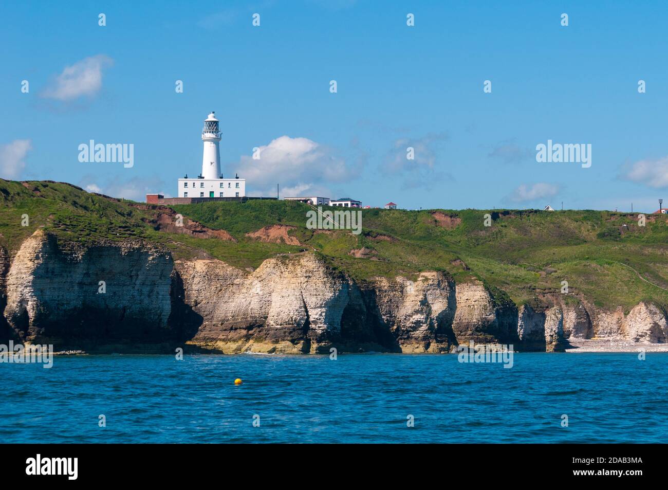 Il faro di Flamborough Head sopra le scogliere di gesso viste dal mare. Flamborough, East Yorkshire. Giugno. Foto Stock
