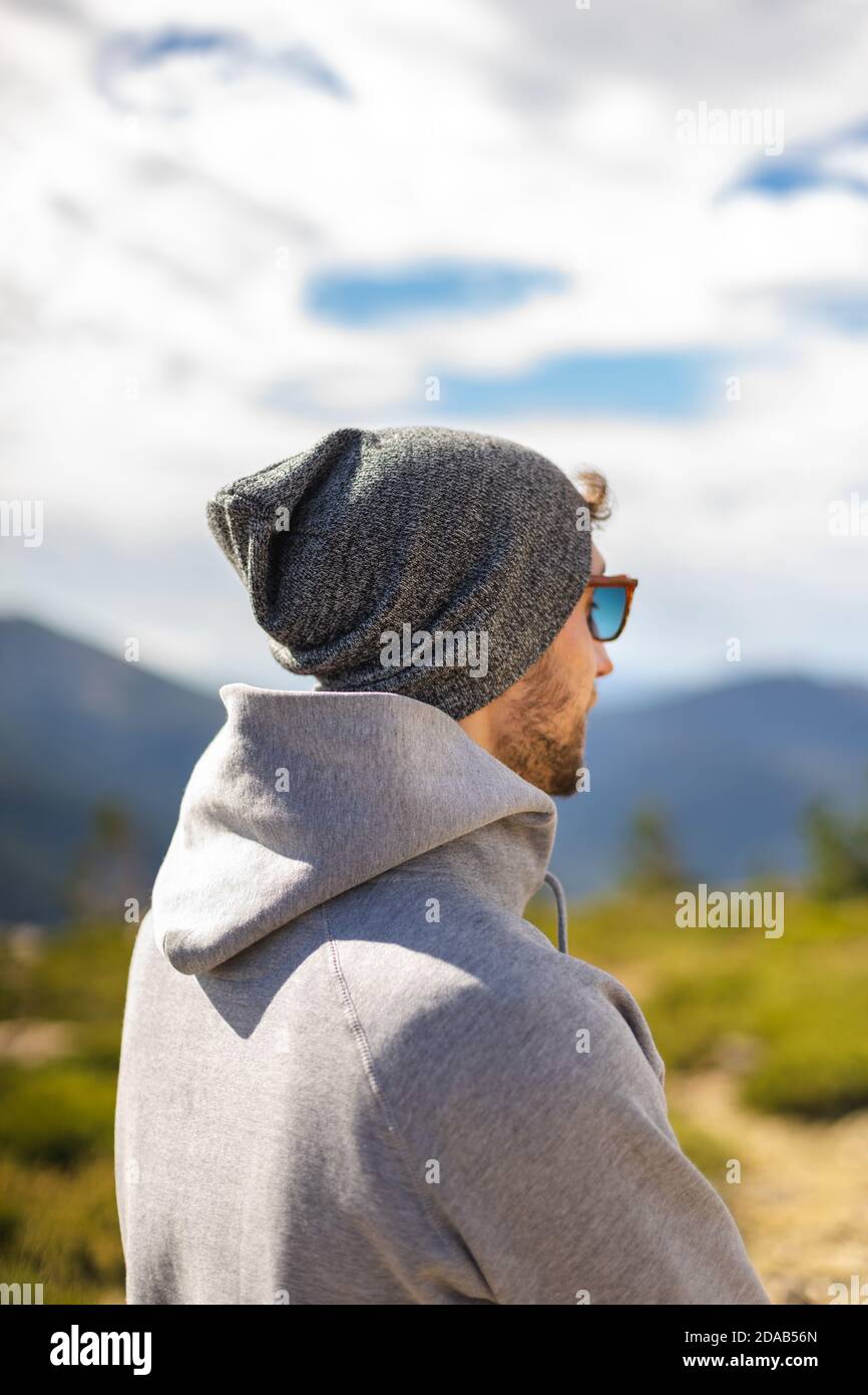 Giovane uomo bianco da dietro con occhiali da sole in una bella ambiente naturale circondato da montagne in uno stile informale Foto Stock Giovane uomo bianco da dietro con occhiali da sole in una bella ambiente naturale circondato da montagne in uno stile informale Foto Stock