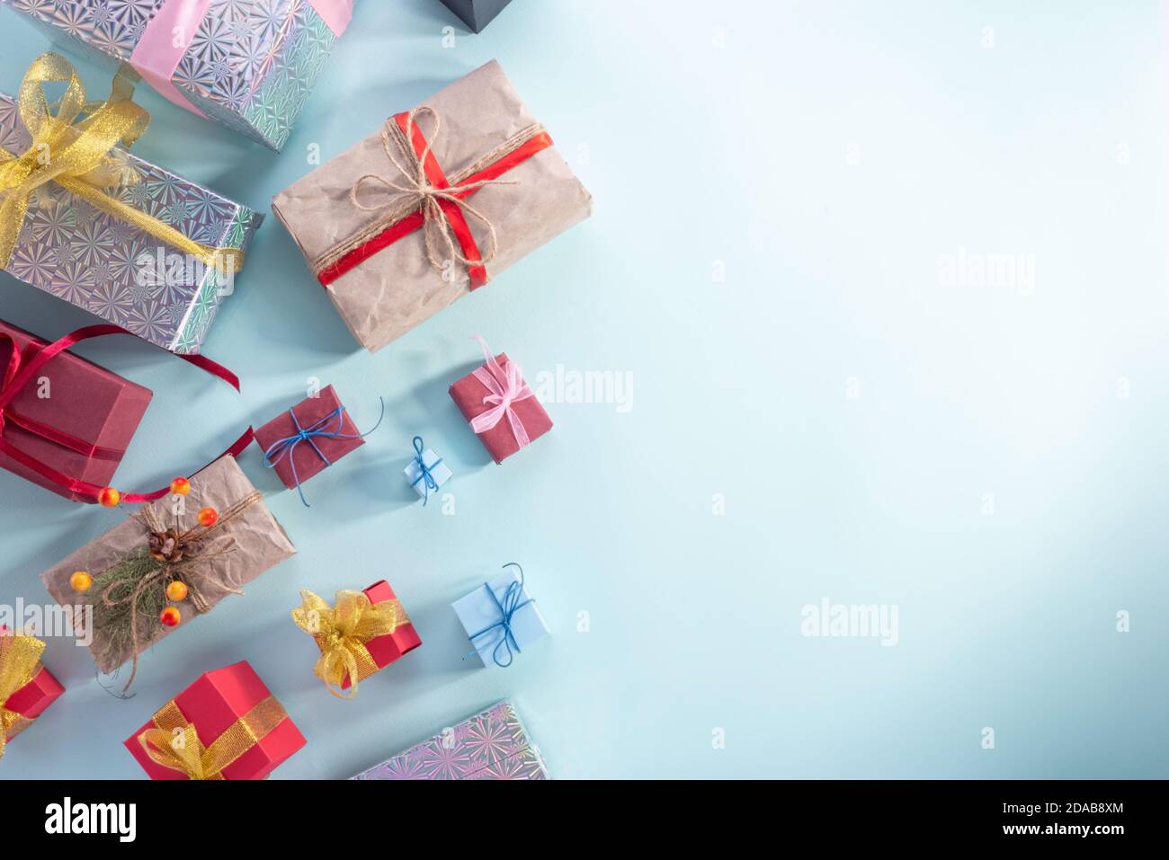 Vista dall'alto, tanti regali di Natale su sfondo blu. New Year flatlay bei regali in confezione d'oro e palline di Natale su sfondo blu Foto Stock