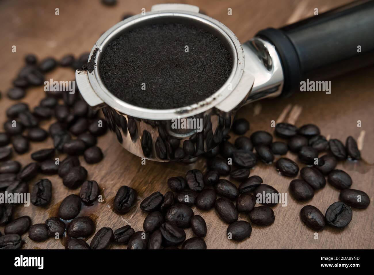 Macine di caffè nel portafiltro della macchina. Fagioli in tutto il posto. Foto Stock