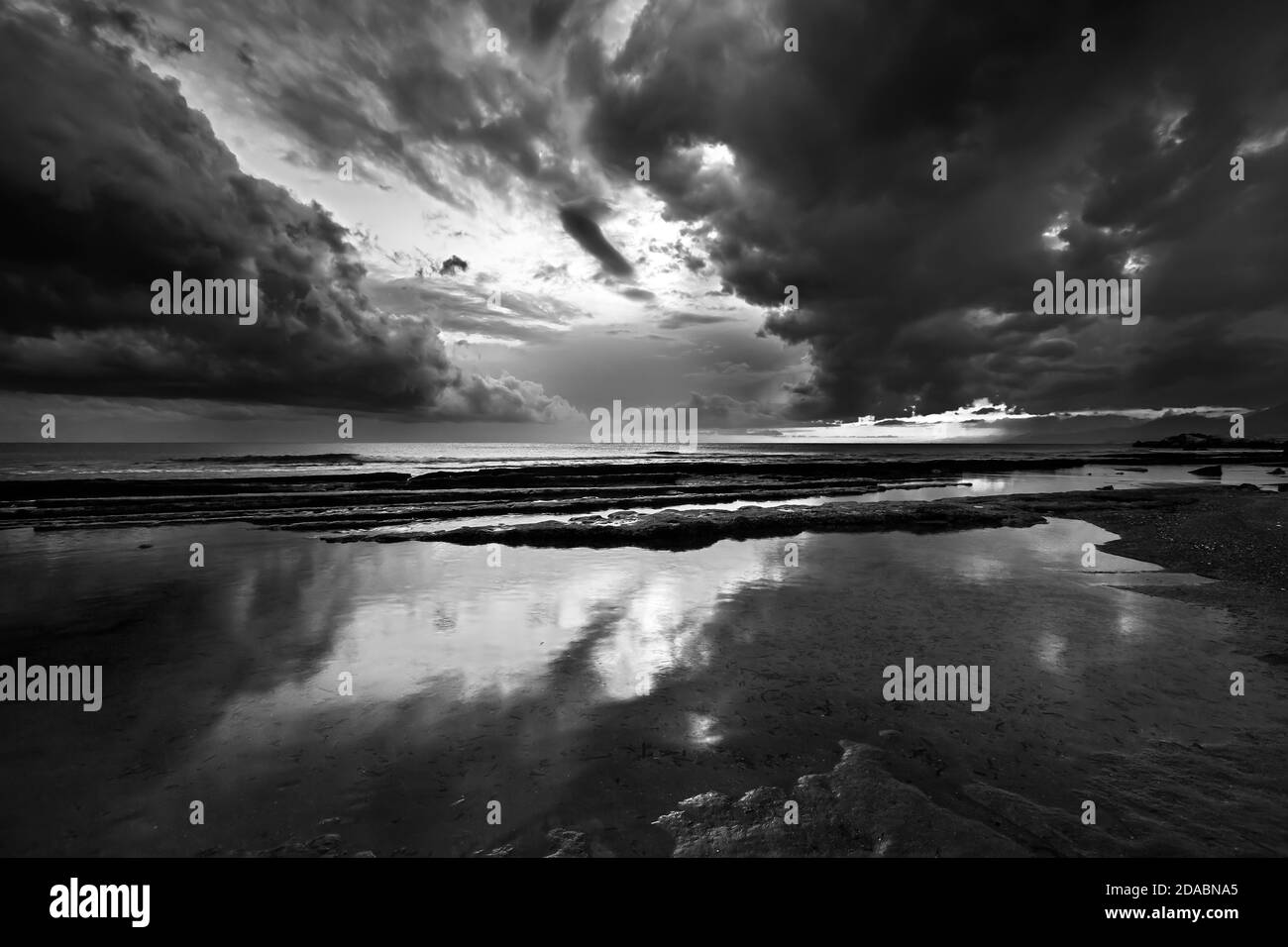 Una spiaggia nella città di Ierapetra (Creta, Grecia), subito dopo il tramonto, ai margini di due stagioni, fine estate, inizio autunno (versione b&w). Foto Stock