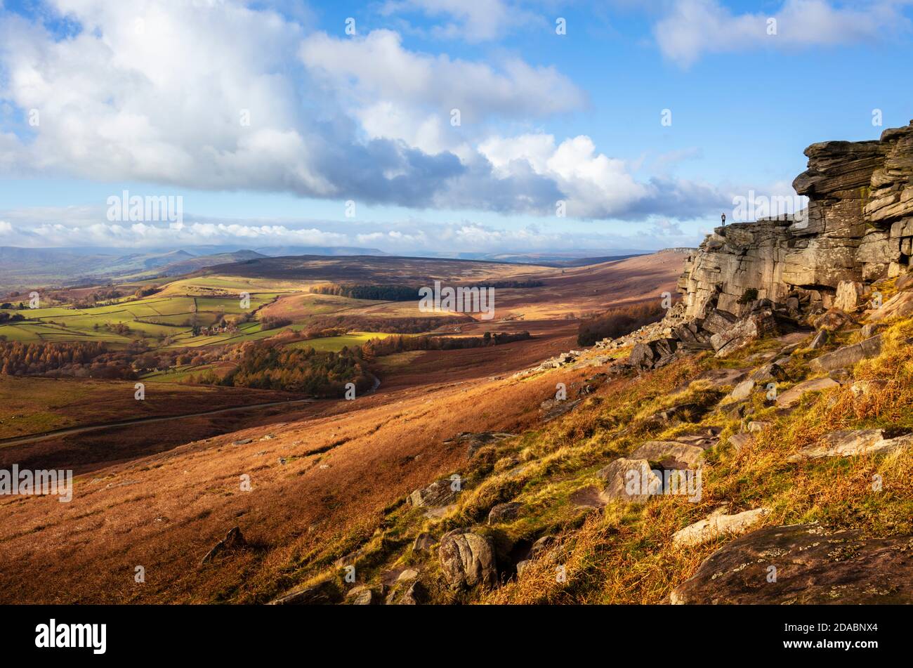 Walker in lontananza su Stanage Edge vicino ad Hathersage Derbyshire Peak District National Park Derbyshire Inghilterra GB Europa Foto Stock