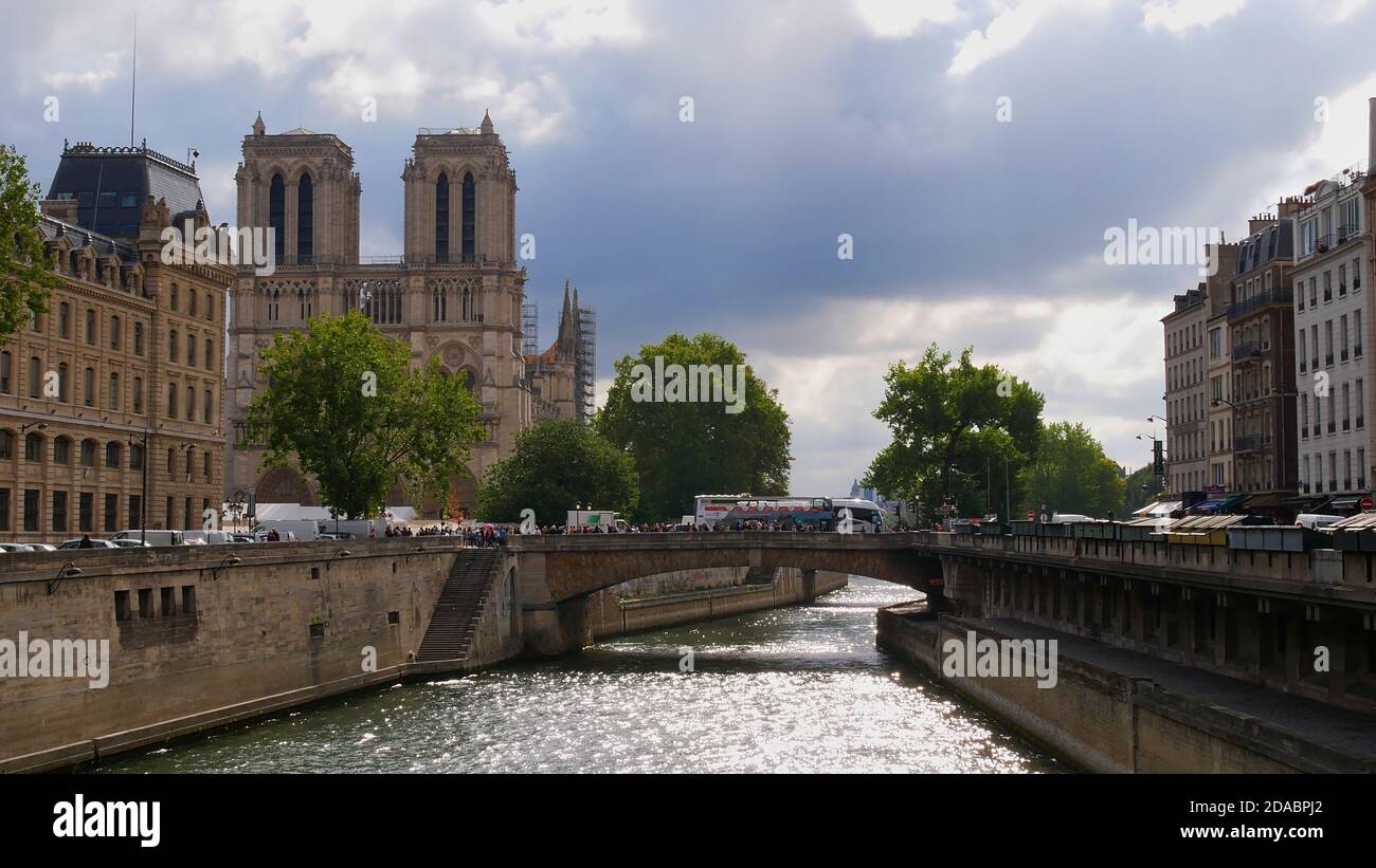 Parigi, Francia - 09/07/2019: Riflessi di luminoso sole d'autunno nelle acque del fiume Senna con la famosa cattedrale Notre-Dame de Paris e la folla di turisti. Foto Stock