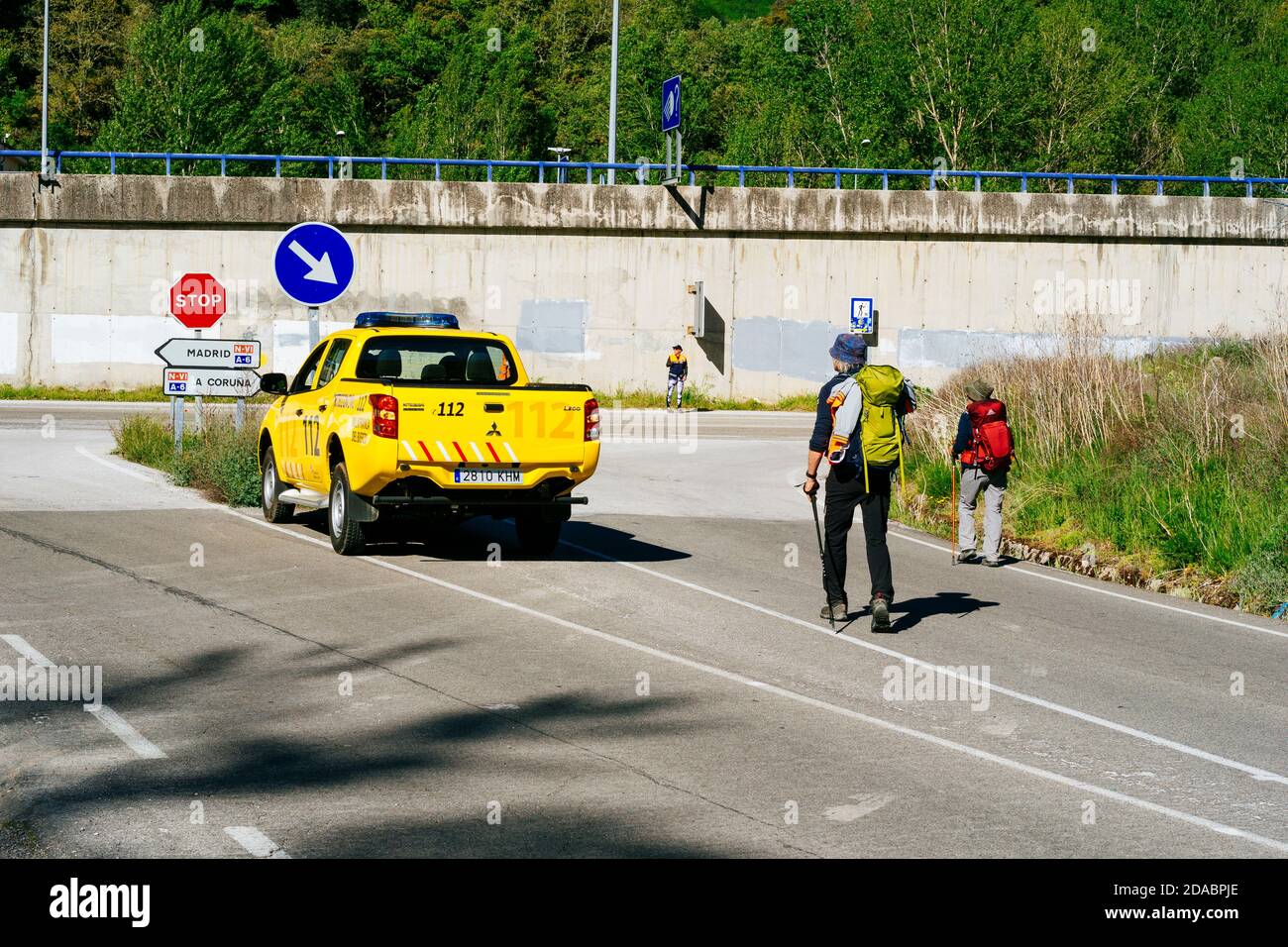 Il personale della protezione civile aiuta i pellegrini attraversando la strada N-VI e l'accesso all'autostrada A-6. Modo francese, modo di San Giacomo. Villafranca del Bierzo Foto Stock