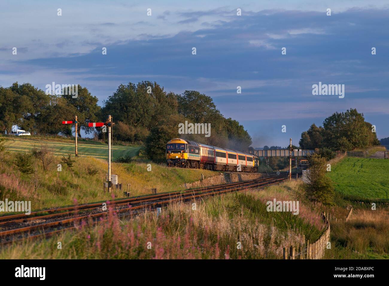 Servizi di locomotiva classe 47 locomotiva 47712 che passa i segnali semaforici All'incrocio con il treno turistico 'Staycation Express' vuoto scorte Foto Stock