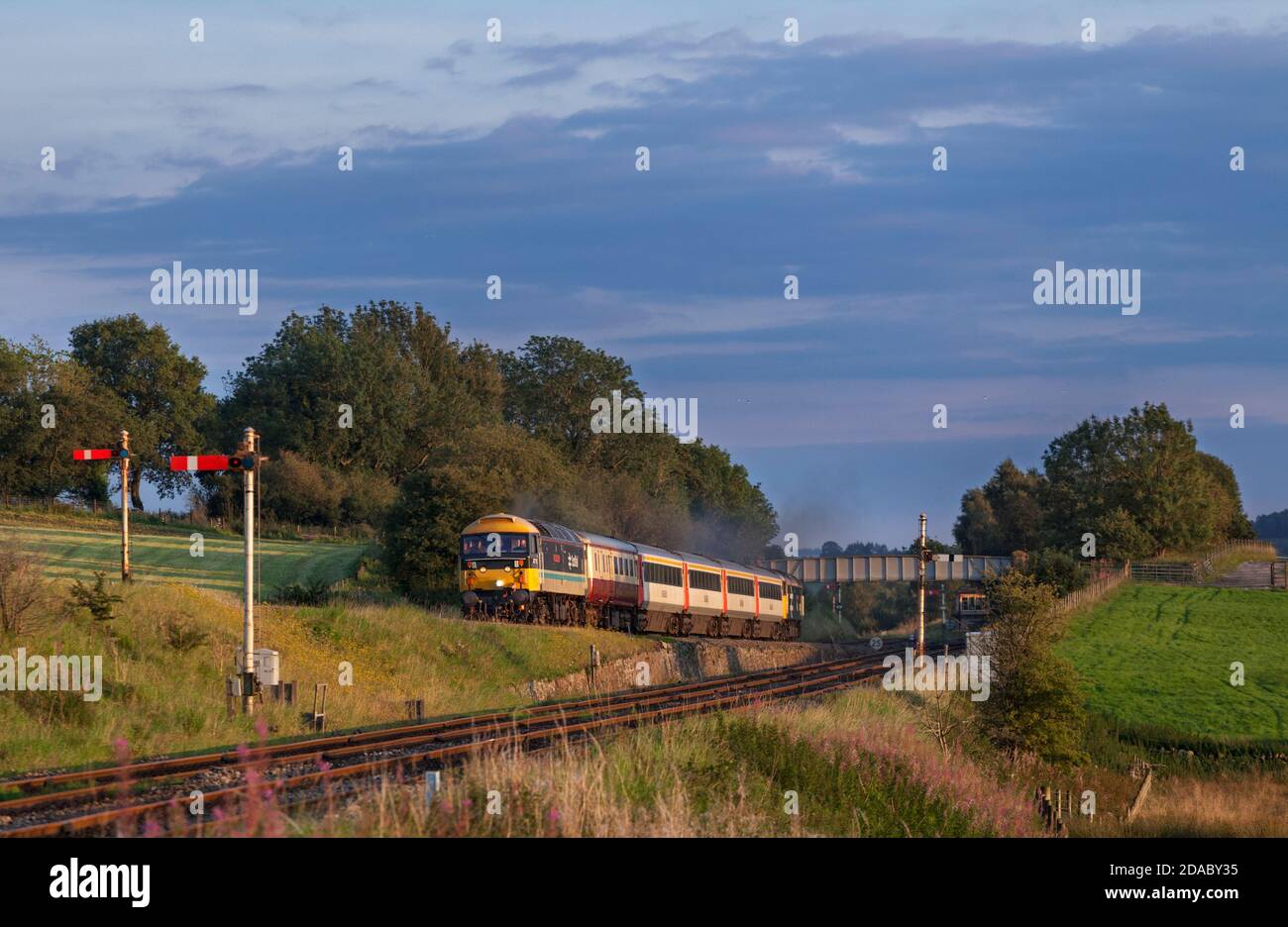Servizi di locomotiva classe 47 locomotiva 47712 che passa i segnali semaforici All'incrocio con il treno turistico 'Staycation Express' vuoto scorte Foto Stock