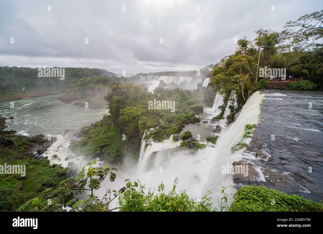 Vista lungo le fragorose acque dell'Iguazzu a molte isole e rocce sopravvolte dalla giungla. Le cascate di Iguazzu sono le cascate più grandi del mondo. Foto Stock