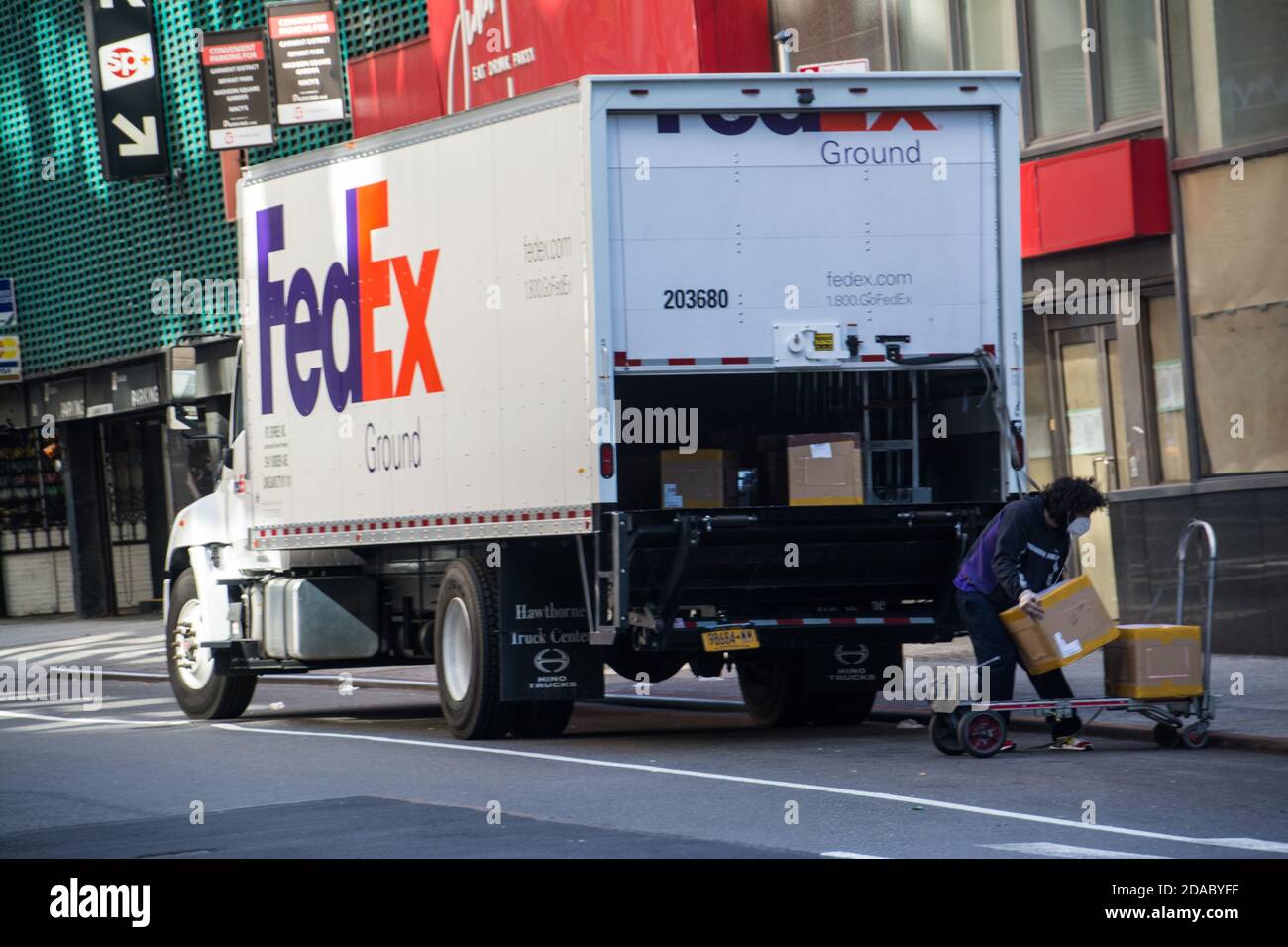 FedEx Essential Worker come estrarre i pacchetti dal camion in New York City durante il Covid-19 Pandemic Foto Stock