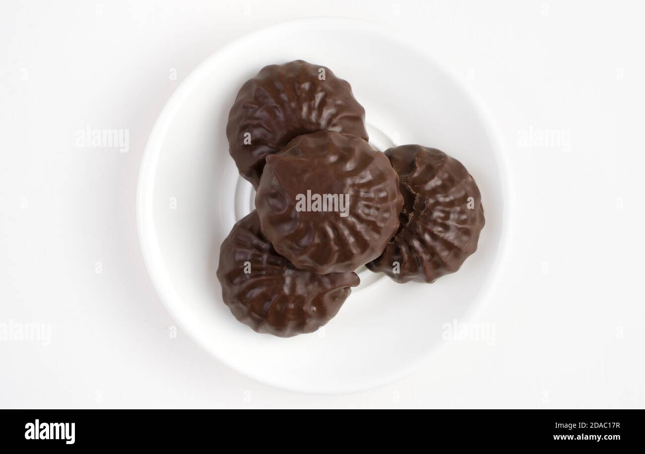 Il marshmallow al cioccolato da dessert è in un piatto bianco su uno sfondo chiaro. Foto Stock