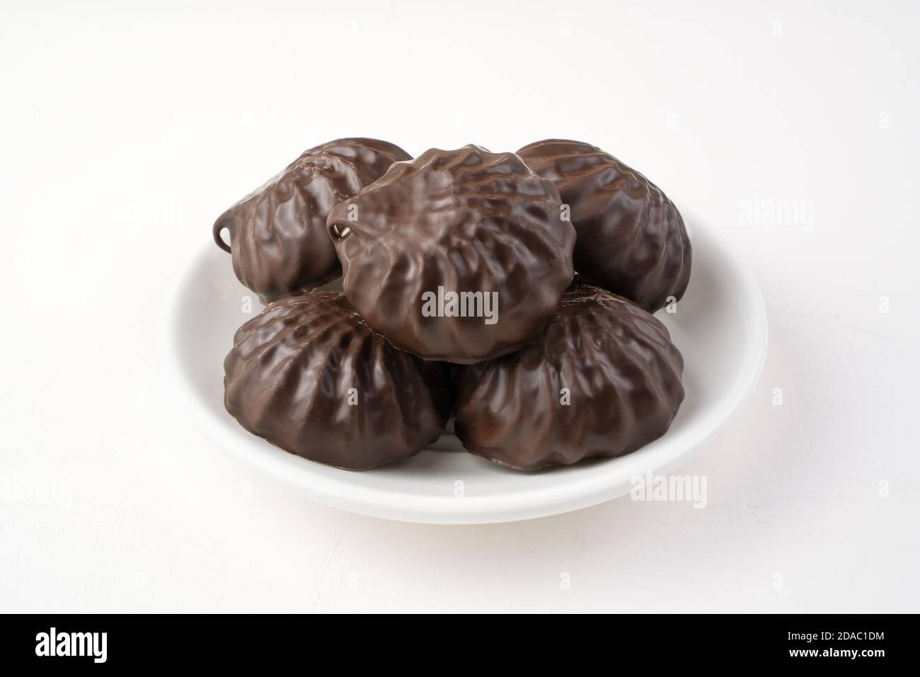 Marshmallows ricoperti di cioccolato su un piatto bianco. Vista laterale. Foto Stock
