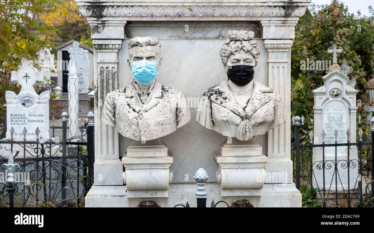 Monumento funerario storico con mascherine di protezione del virus Corona/Covid, Craiova, Dolj, Romania, UE. Foto Stock