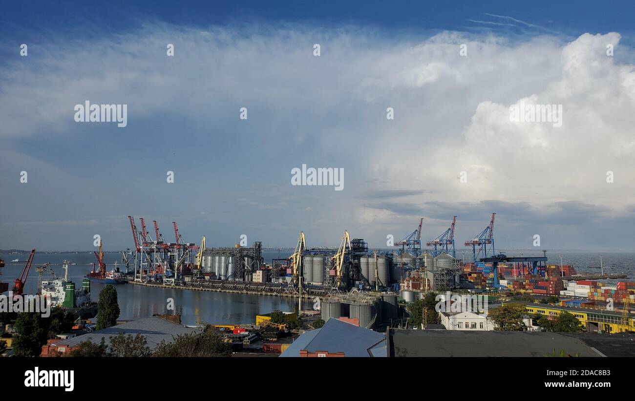 Porto con terminale elevatore granella e area contenitore. Vista industriale del mare sotto nuvole tempestose in alto cielo. Porto marittimo paesaggio nel porto di Foto Stock