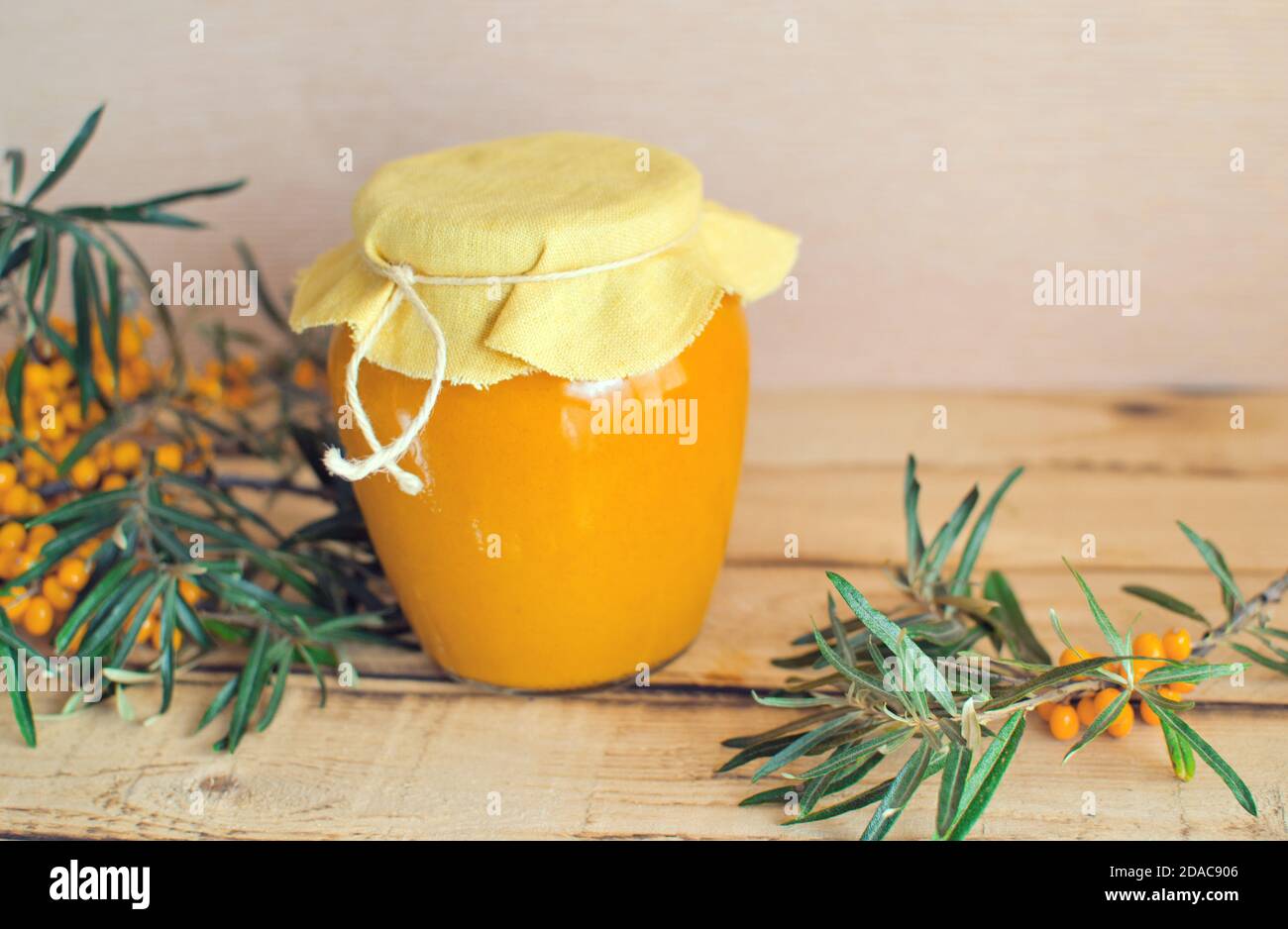 Vasetto di vetro con sciroppo di fibbone di mare sul legno rustico tabella Foto Stock