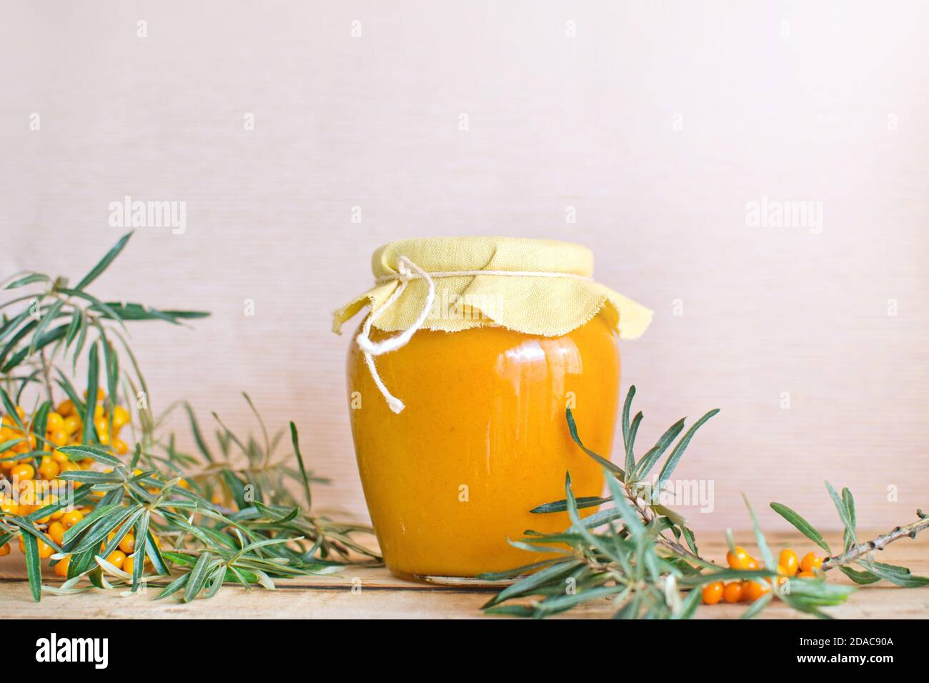 Vasetto di vetro con sciroppo di fibbone di mare sul legno rustico tabella Foto Stock