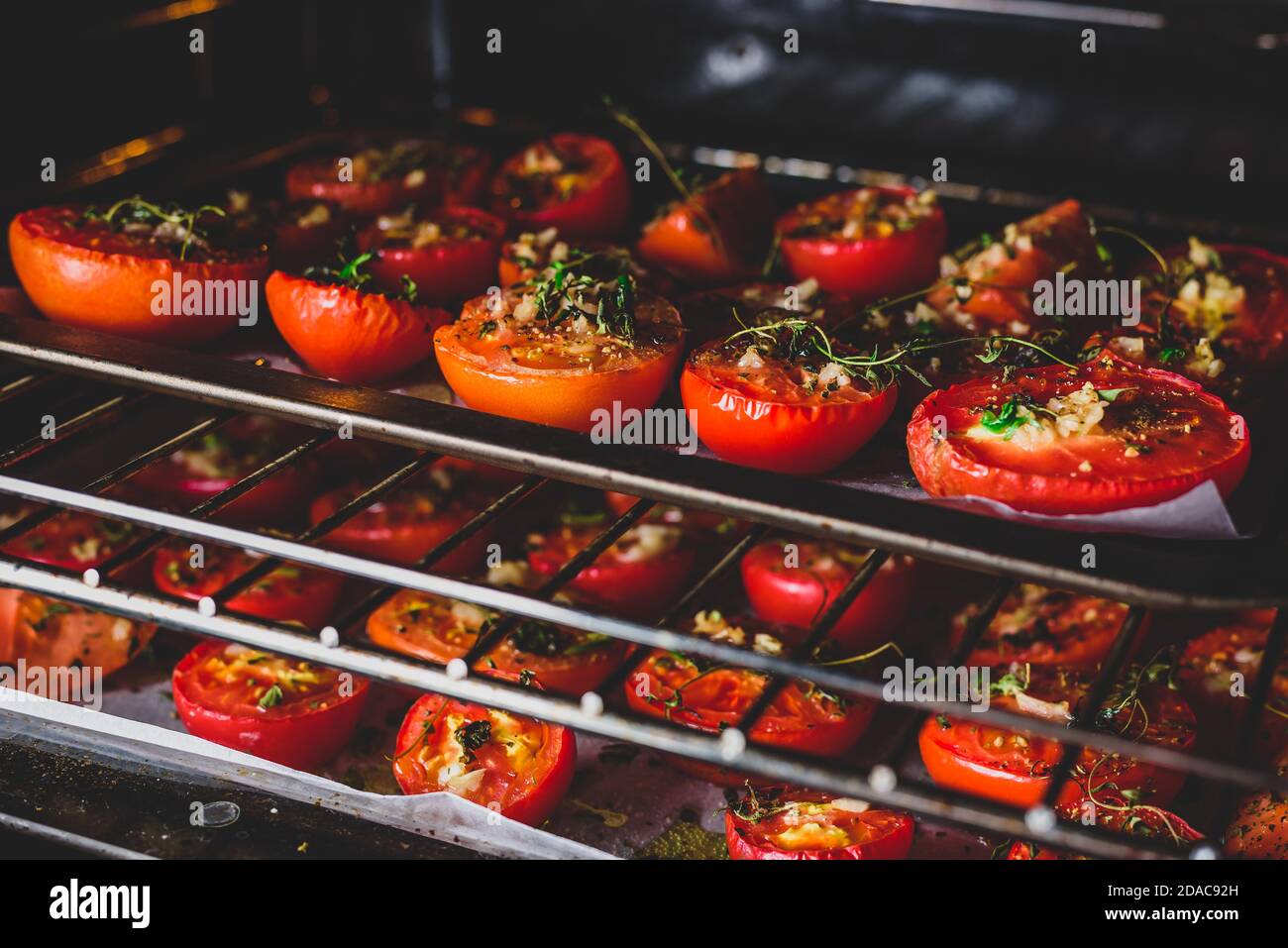 Cottura di pomodori con erbe e aglio in forno Foto Stock