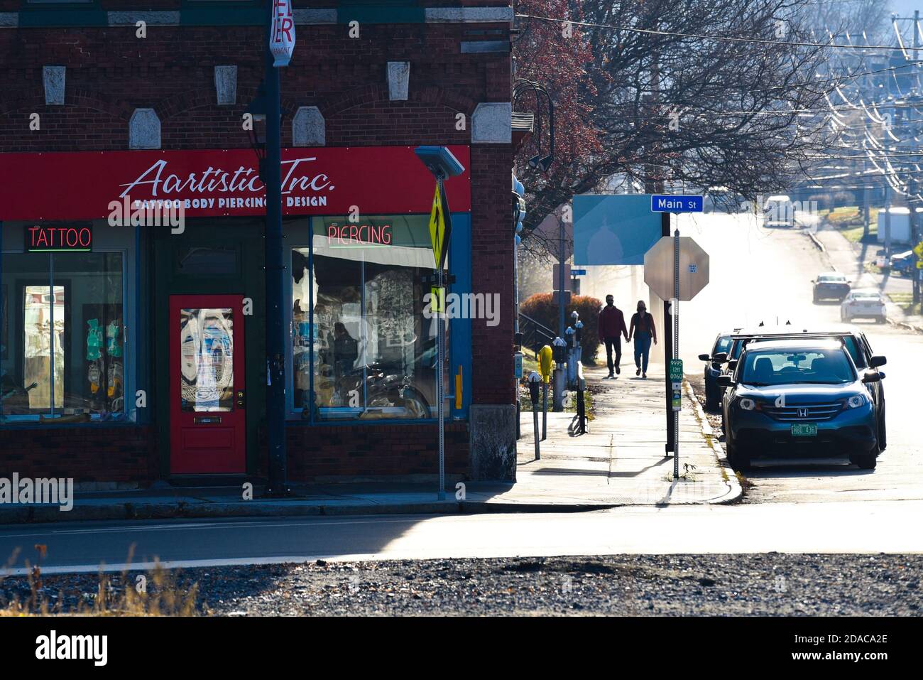 Coppia passeggiando mano in mano vicino Tattoo Parlor Montpelier, capitale del Vermont, Stati Uniti. Foto Stock