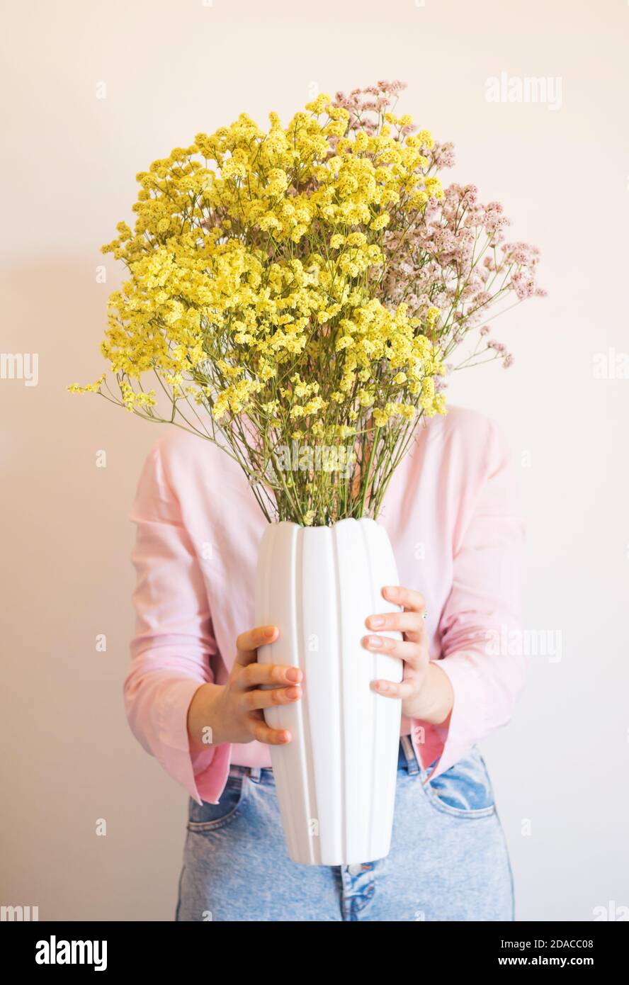 Giovane donna in camicia rosa con vaso di fiori Foto stock - Alamy