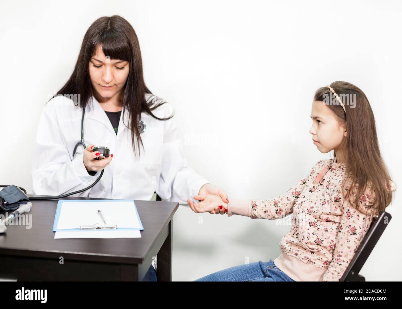 Prescolare visita medica della ragazza caucasica, medico che misura la pressione sanguigna di un bambino Foto Stock