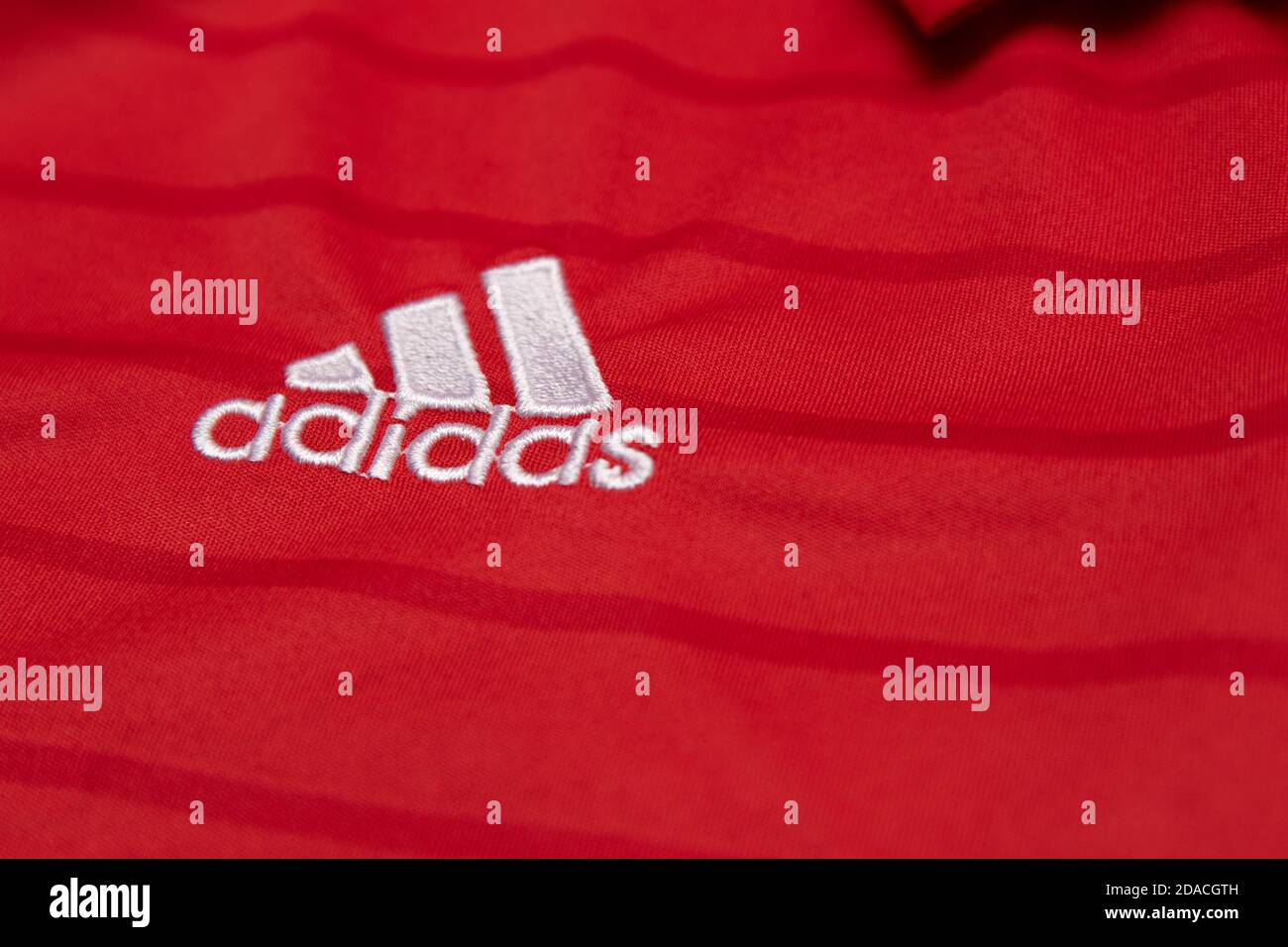 Logo in argento bianco adidas di montagna ricamato su un calcio rosso  camicia a righe sottili Foto stock - Alamy