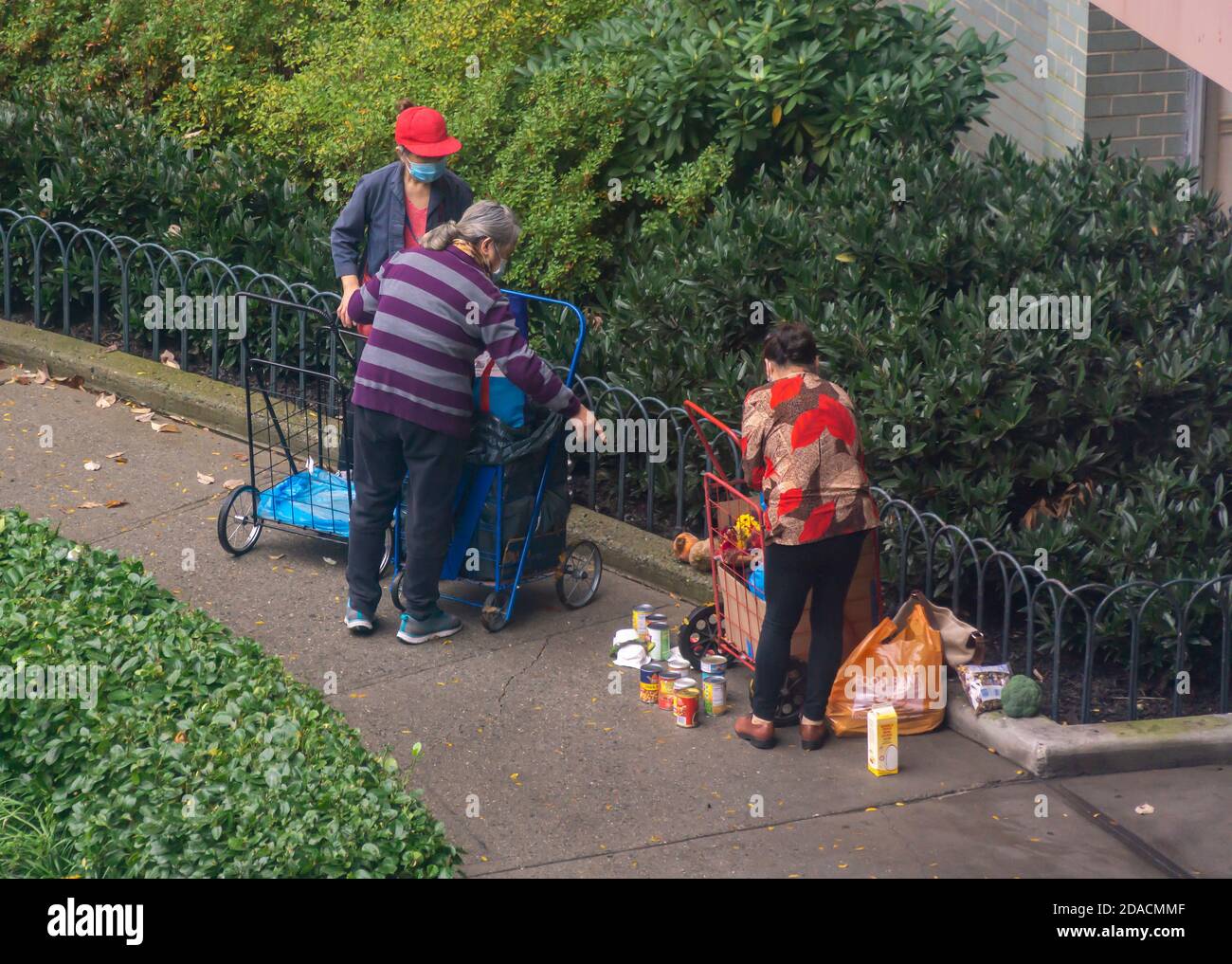 I destinatari di una dispensa di cibo a New York ridistribuiscono la loro grandezza di fronte ad un edificio di appartamenti a Chelsea mercoledì 11 novembre 2020 (© Richard B. Levine) Foto Stock