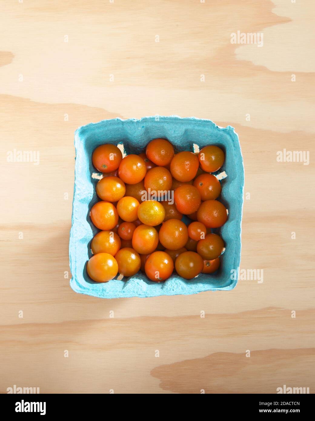 Pinta secca di pomodori ciliegia d'arancia su tavola di legno. Foto Stock