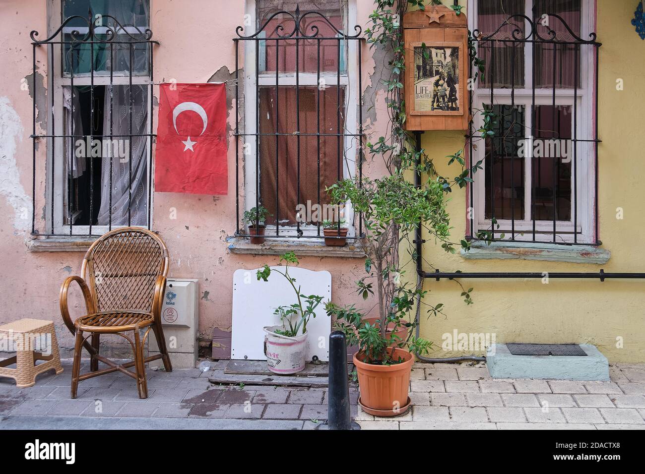 Vista della parte anteriore di una casa sul retro Strade di Balat con finestre bar una bandiera turca e. una scatola di lettere di legno con un poster del film La vita è essere Foto Stock