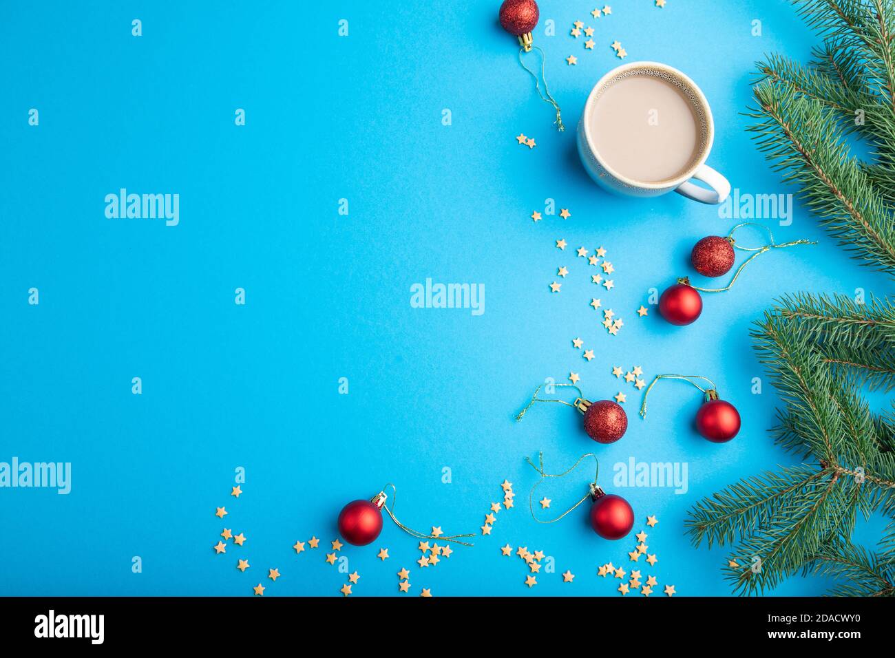 Composizione di Natale o Capodanno. Decorazioni, palline rosse, rami di abete e abete rosso, tazza di caffè, su fondo di carta blu. Vista dall'alto, spazio copia, f Foto Stock