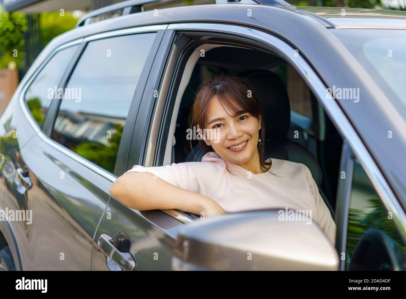 Asian felice giovane bella donna che guida un'auto sul sedile anteriore con sorriso prepararsi a viaggiare con la sua auto. Foto Stock
