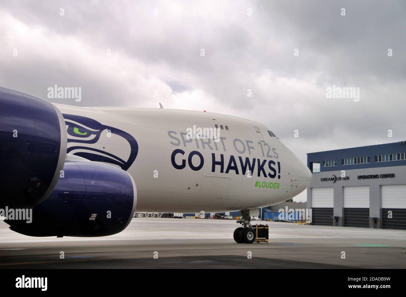 Il parcheggio della squadra di football dei Seahawks Boeing 747-8 Freighter si trova di fronte all'edificio del Dreamlifter Operations Center all'aeroporto di Plainfield, Everett, Washington Foto Stock
