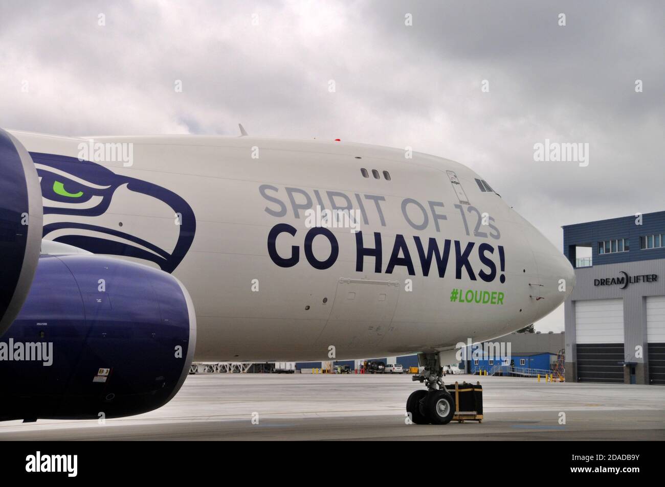 Il parcheggio della squadra di football dei Seahawks Boeing 747-8 Freighter si trova di fronte all'edificio del Dreamlifter Operations Center all'aeroporto di Plainfield, Everett, Washington Foto Stock
