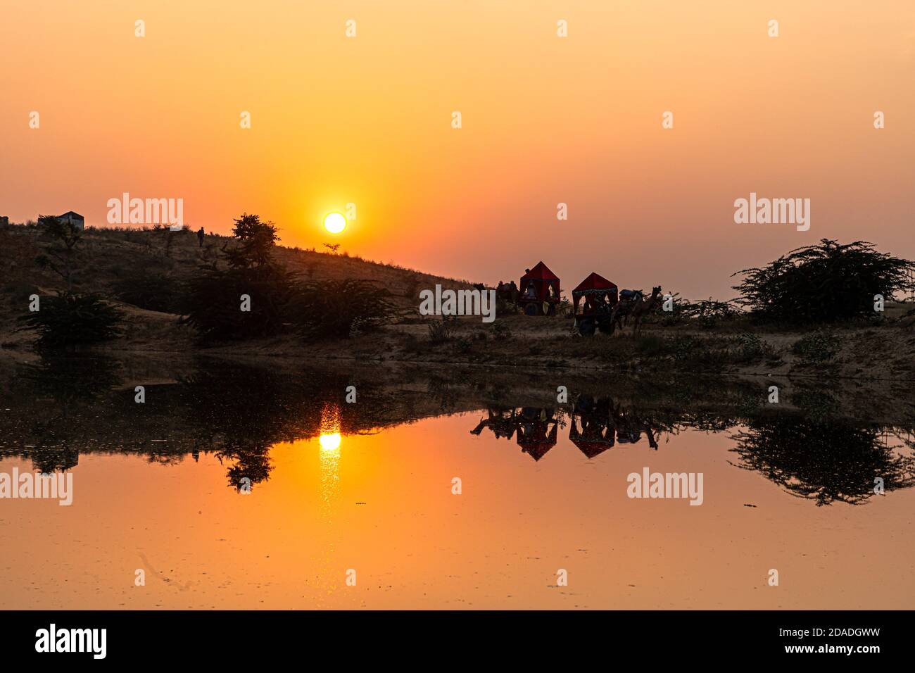 vista di un bellissimo tramonto e uno stagno e riflesso di carretto cammello in acqua. Foto Stock