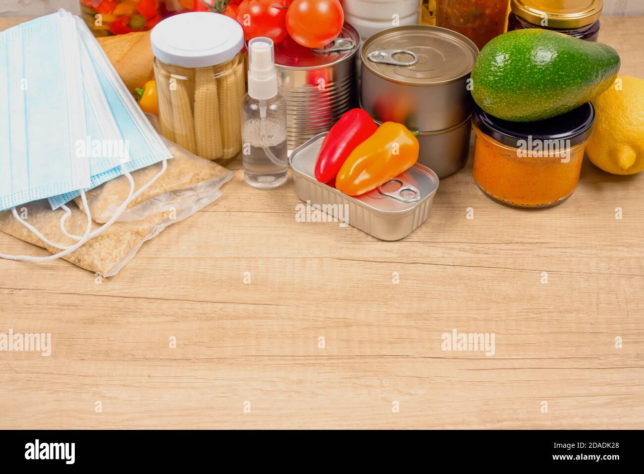 Donazioni di cibo e medicine su tavola di legno come sfondo con copyspace - pasta, verdure fresche, cibo in scatola, baguette, olio da cucina, monouso Foto Stock