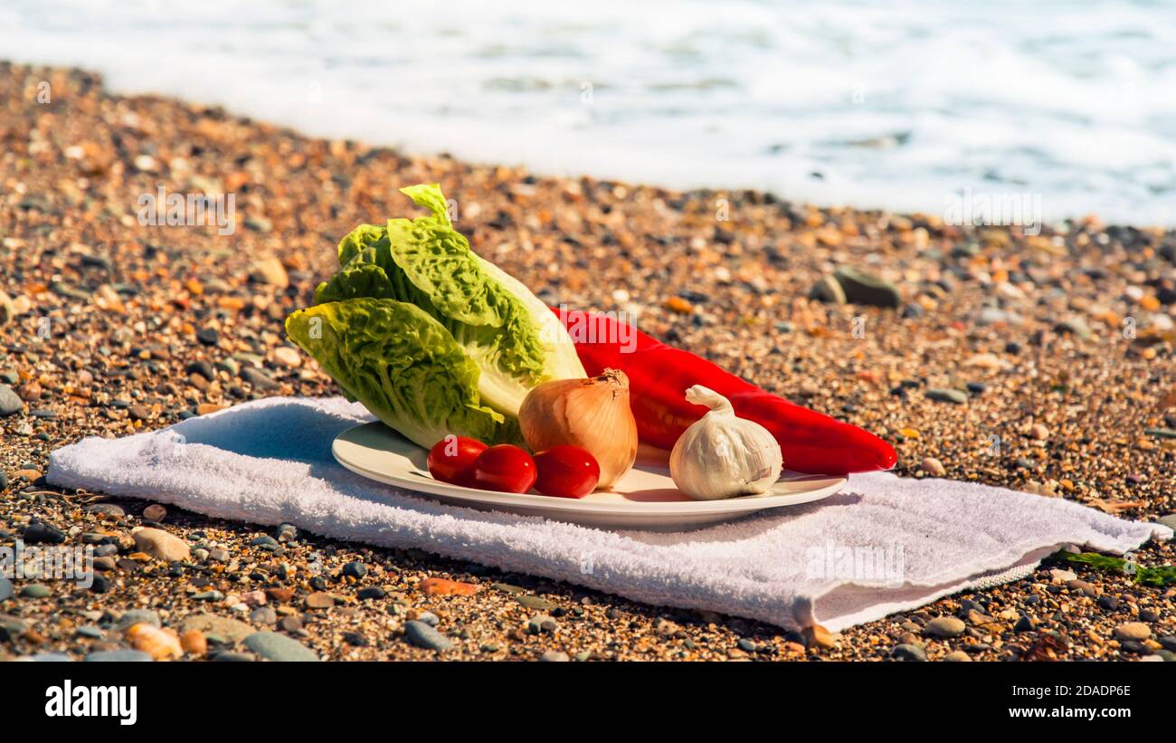 Verdure sul piatto con il mare sullo sfondo Foto Stock