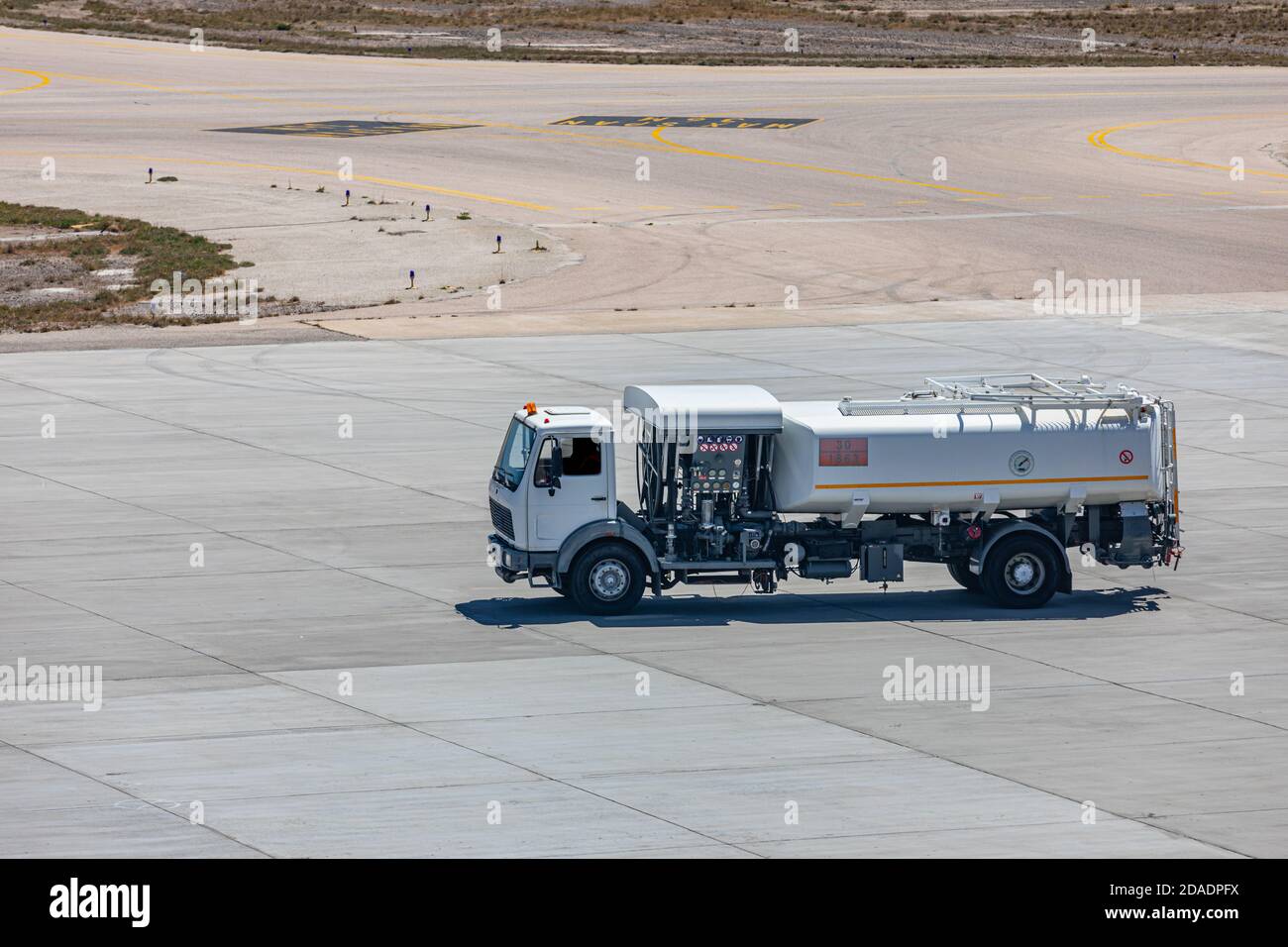 Carrello bianco con serbatoio carburante sulla pista. Il veicolo a carburante è in attesa di riempire alcuni aerei con carburante liquido Foto Stock