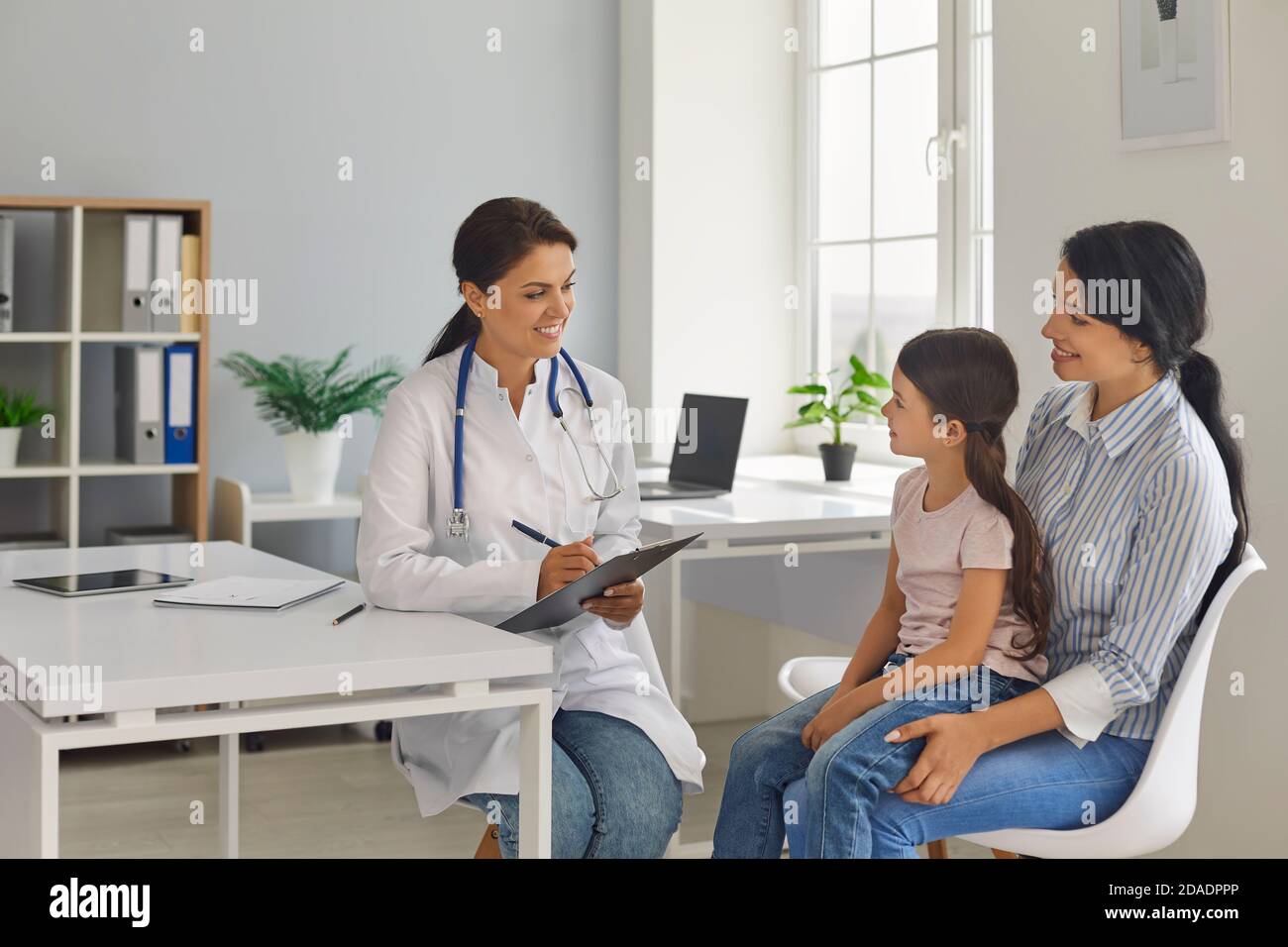 Madre e bambina in ufficio medico. Il pediatra prescrive il trattamento al paziente. Medico. Foto Stock