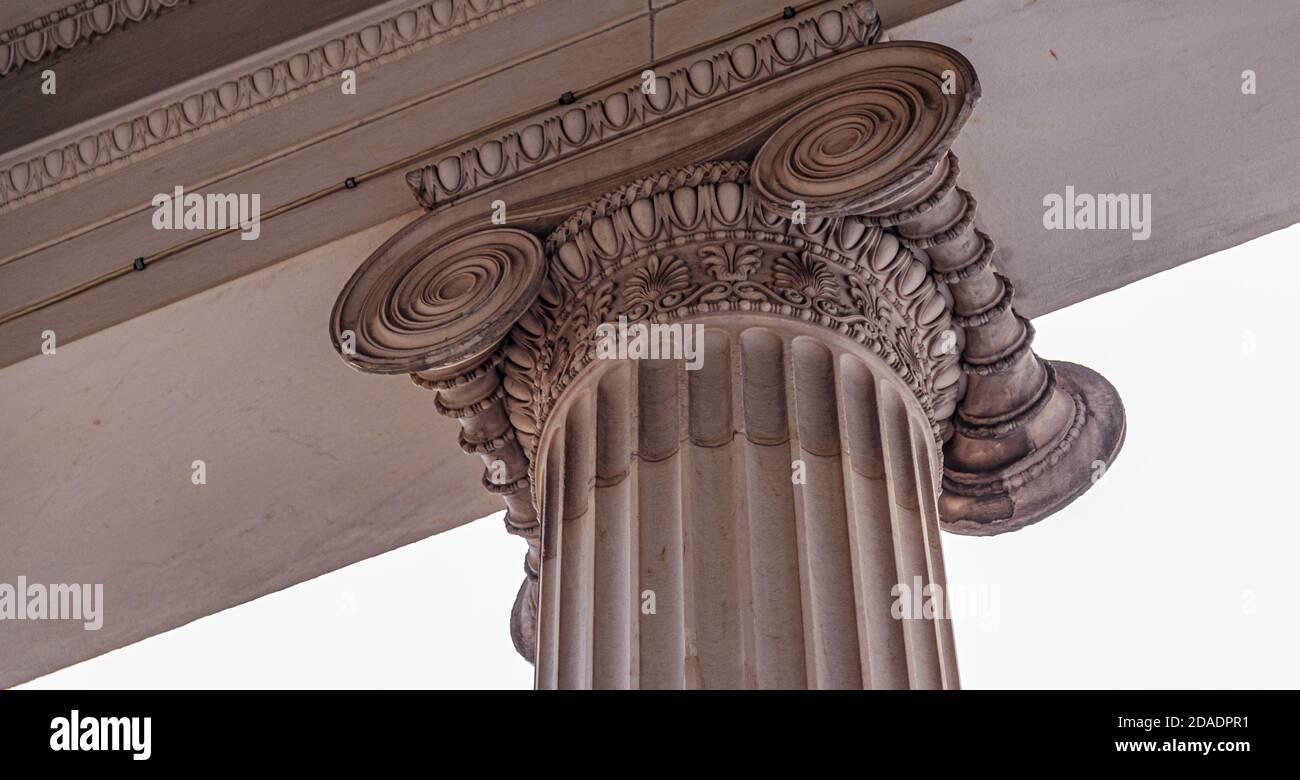 Particolare decorativo di un'antica colonna greca. Dettaglio dell'architettura primo piano della colonna. Colonna classica di ordine ionico. Antica capitale di marmo Foto Stock